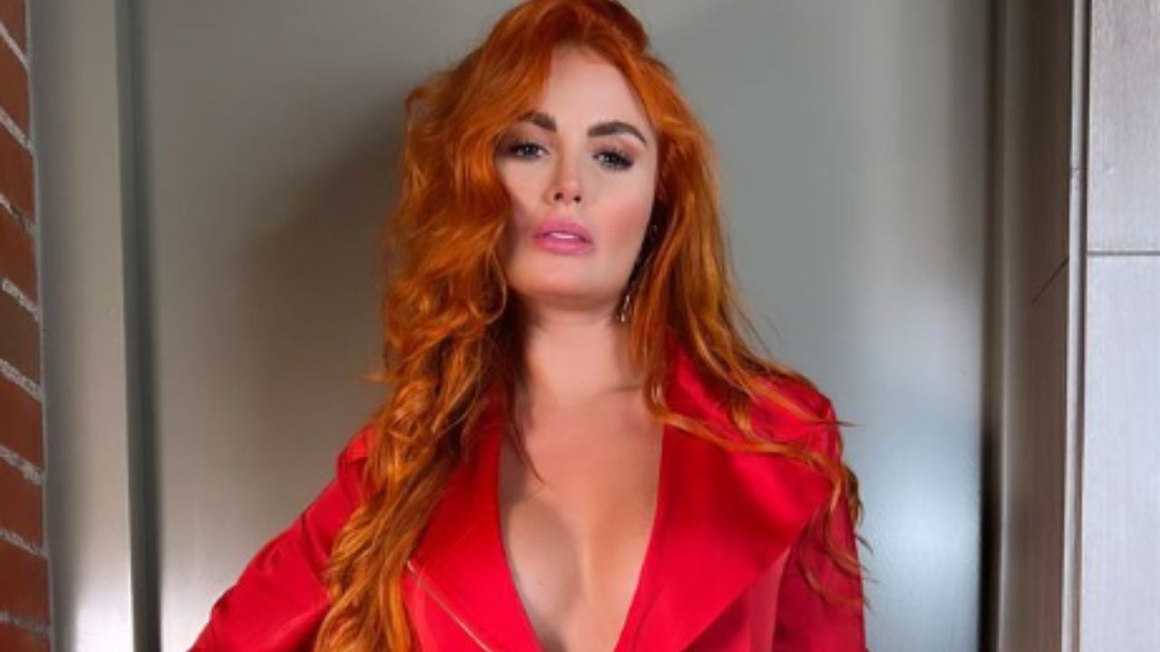 Sara Uribe modelo y presentadora luce un sensual vestido enterizo rojo con un pronunciado escote que resalta se pecho.