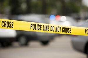 Cordon tape seals off an active crime scene.