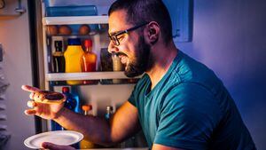 Hombre comiendo durante la noche