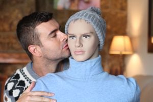 Handsome man kissing a mannequin.