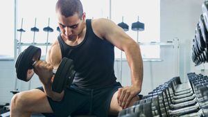 Hombre en el gimnasio realizando ejercicios para fortalecer los bíceps