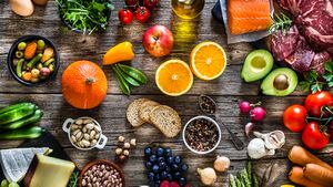 Fondos de comida: vista superior de una mesa rústica de madera llena de diferentes tipos de comida. La composición incluye filete de ternera crudo, filete de salmón crudo, frutas, verduras, queso, pan, huevos, legumbres, aceite de oliva y nueces. Foto de estudio DSRL tomada con Canon EOS 5D Mk II y Canon EF 70-200mm f/2.8L IS II USM Telephoto Zoom Lens