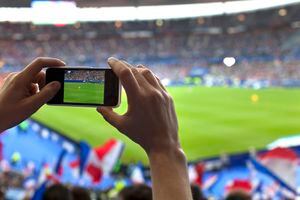 Persona graba con su celular en un estadio