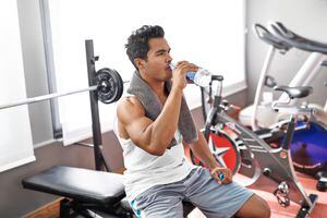 Hombre se hidrata mientras realiza su rutina de ejercicio