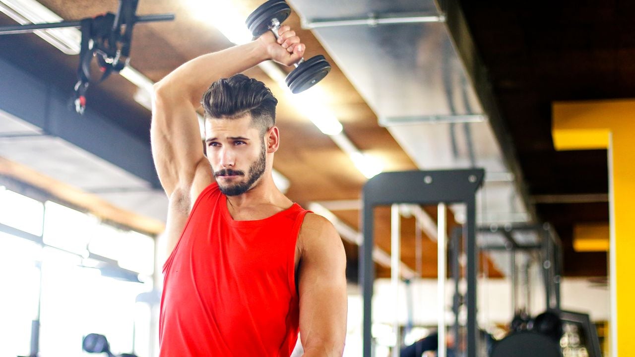 Hombre en el gimnasio fortalece sus tríceps