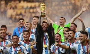 Soccer Football - FIFA World Cup Qatar 2022 - Final - Argentina v France - Lusail Stadium, Lusail, Qatar - December 18, 2022 Argentina's Lionel Messi lifts the World Cup trophy alongside teammates as they celebrate winning the World Cup REUTERS/Carl Recine