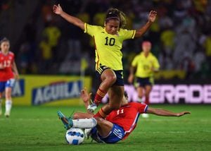 La colombiana Leicy Santos (arriba) es desafiada por la chilena Yessenia López durante su partido del torneo de fútbol femenino de la Copa América Conmebol 2022 en el estadio Centenario de Armenia, Colombia, el 20 de julio de 2022. (Foto de JUAN BARRETO / AFP)