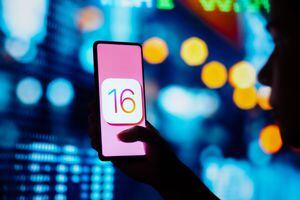 BRAZIL - 2022/06/29: In this photo illustration, a silhouetted woman holds a smartphone with the iOS 16 (Apple) logo displayed on the screen. (Photo Illustration by Rafael Henrique/SOPA Images/LightRocket via Getty Images)