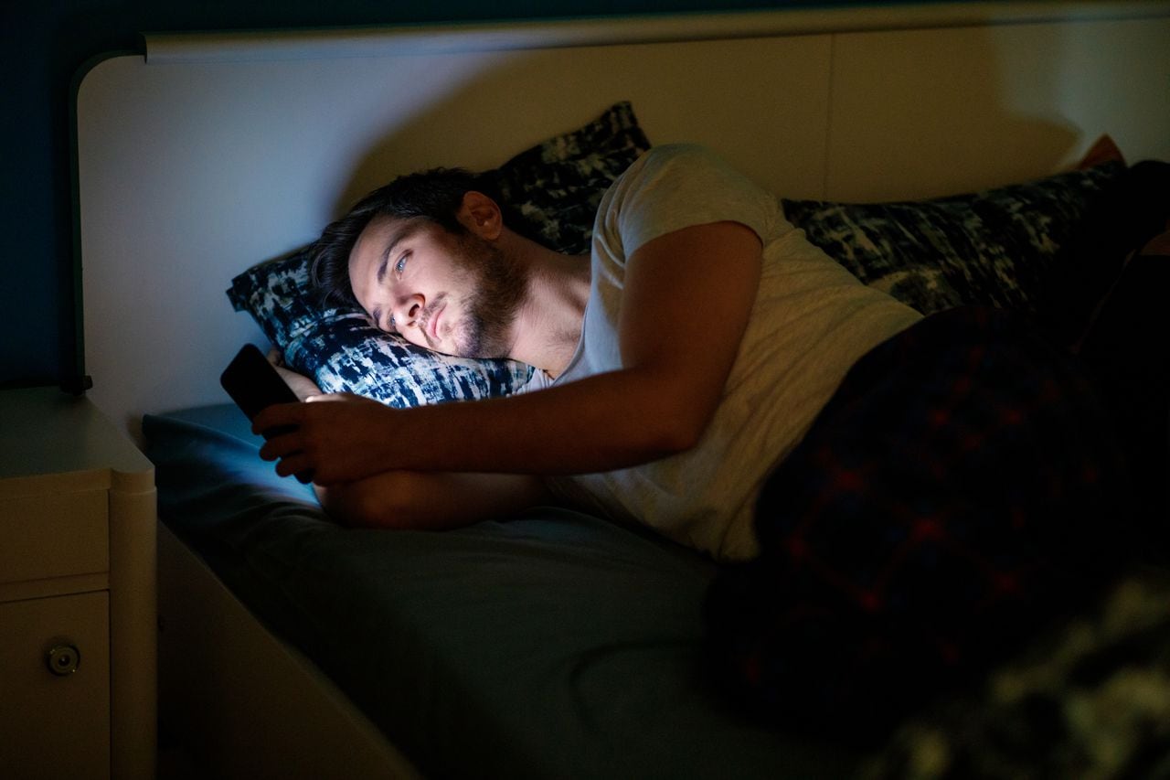 Un joven no puede conciliar el sueño por estar revisando su celular
