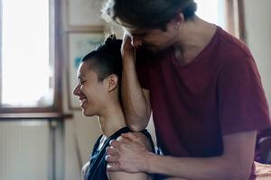 A man giving his girlfriend a sports massage after working out together at home.