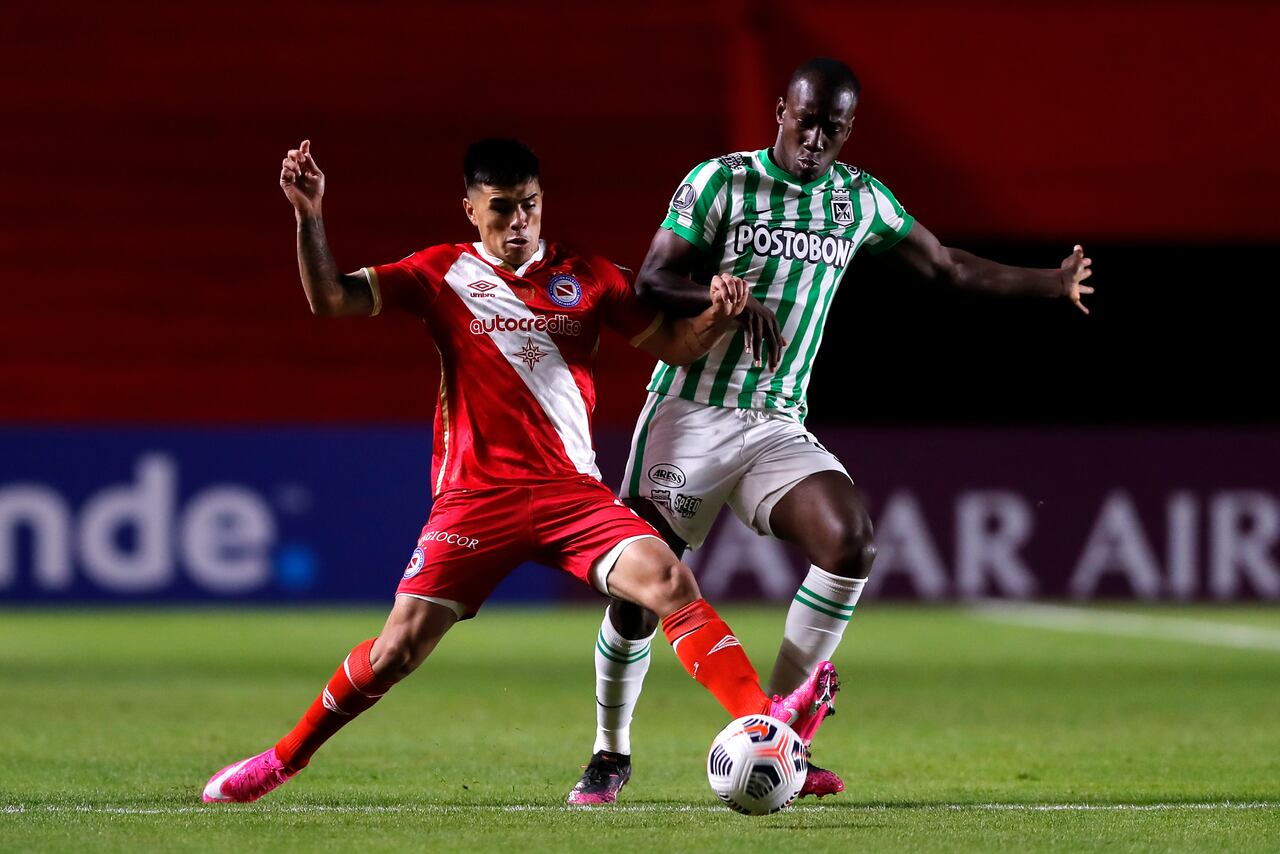 Baldomero Perlaza de Atletico Nacional lucha el balón con César Florentín de Argentinos Juniors durante el partido de la Copa CONMEBOL Libertadores 2021