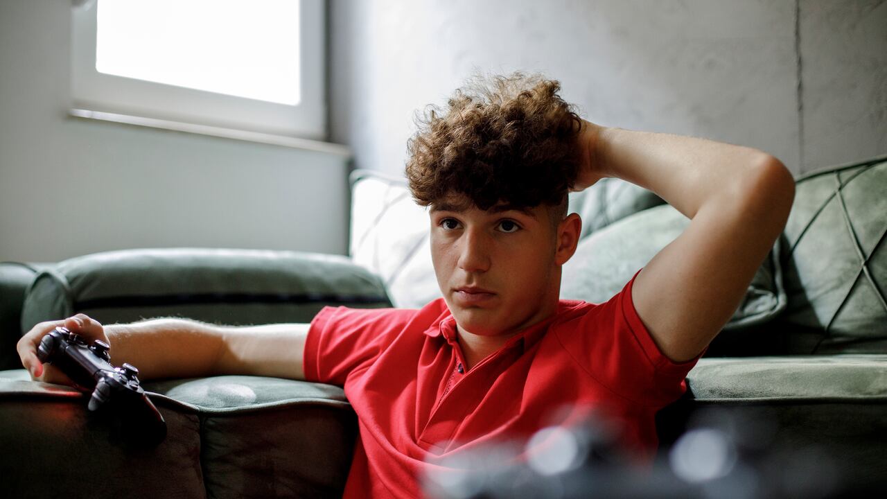 Joven jugando videojuegos en su consola PlayStation.