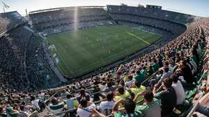 Aficionados del Real Betis alientan a su equipo en el Estadio Benito Villamarín durante el Derbi Sevillano.