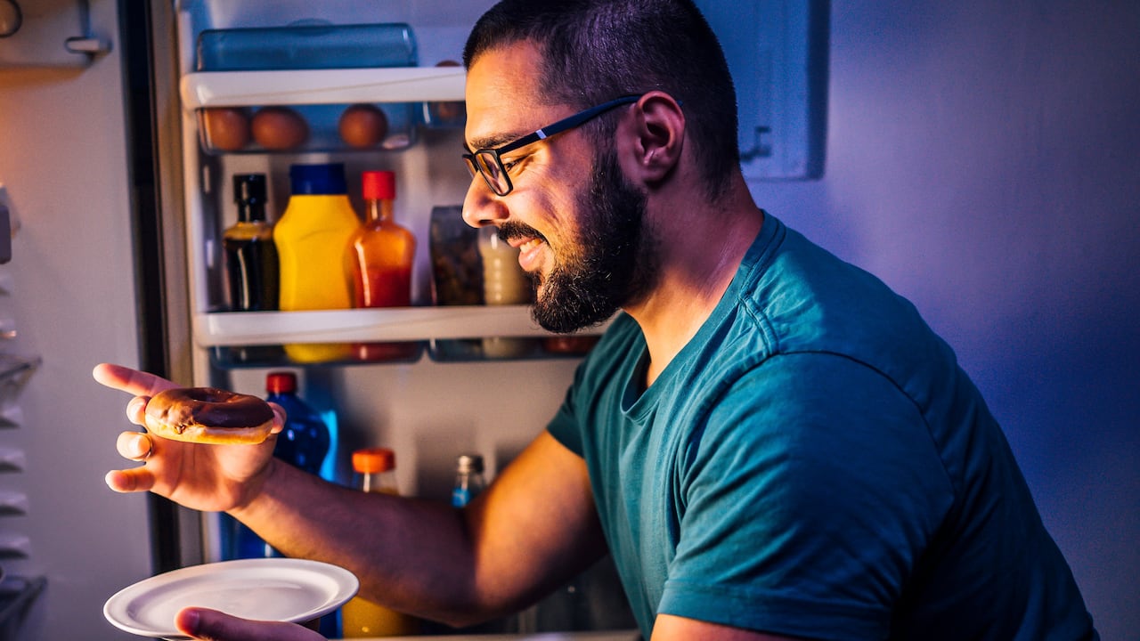 Hombre comiendo durante la noche