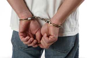 Man in handcuffs behind his back.