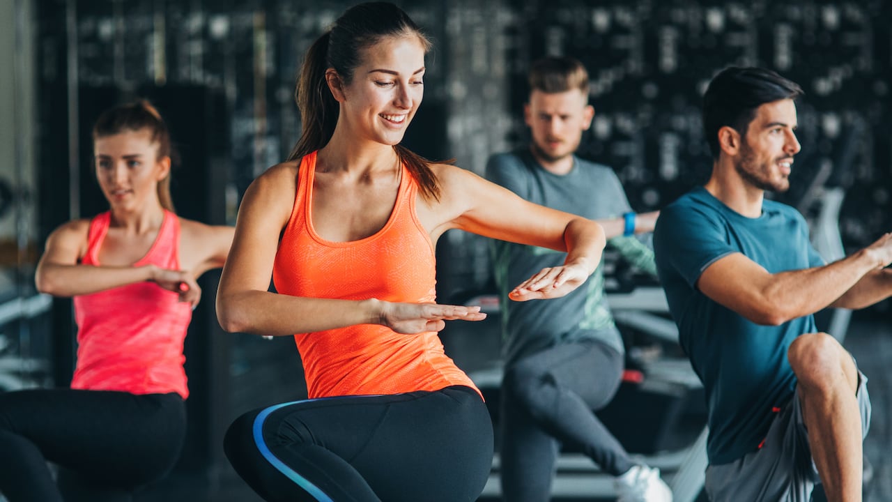 Grupo de personas ejercitándose en el gimnasio en una clase de baile.