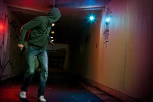 "Thief wearing hood, running in tunel, looking back. revolver in right hand"