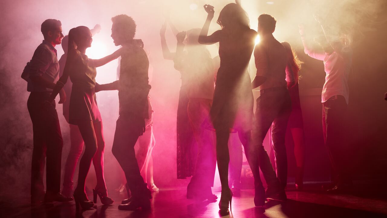 Group of people dancing on dance floor at nightclub