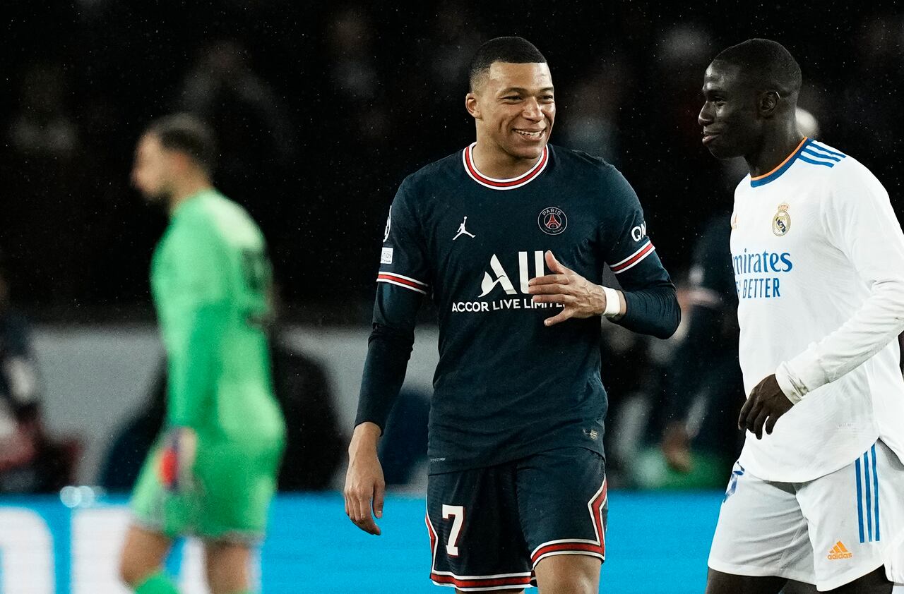 PSG's Kylian Mbappe, center, speaks with Real Madrid's Ferland Mendy during the Champions League, round of 16, first leg soccer match between Paris Saint Germain and Real Madrid at the Parc des Princes stadium, in Paris, France, Tuesday, Feb. 15, 2022. (AP Photo/Thibault Camus)