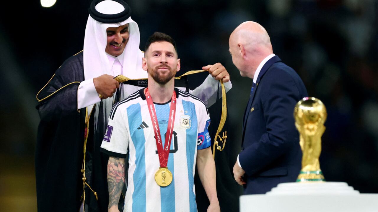 Soccer Football - FIFA World Cup Qatar 2022 - Final - Argentina v France - Lusail Stadium, Lusail, Qatar - December 18, 2022 Argentina's Lionel Messi, Emir of Qatar Sheikh Tamim bin Hamad Al Thani and FIFA president Gianni Infantino during the trophy ceremony REUTERS/Hannah Mckay