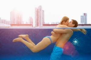 Pareja se besa y tiene intimidad en una piscina