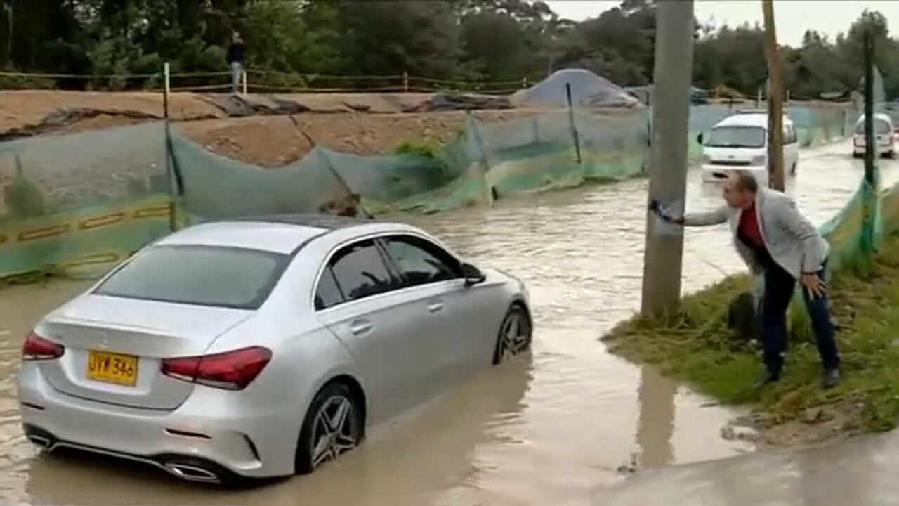 Periodista de 'Noticias Caracol' tuvo que ayudar, en vivo, a conductor de carro de lujo que quedó atrapado por inundación