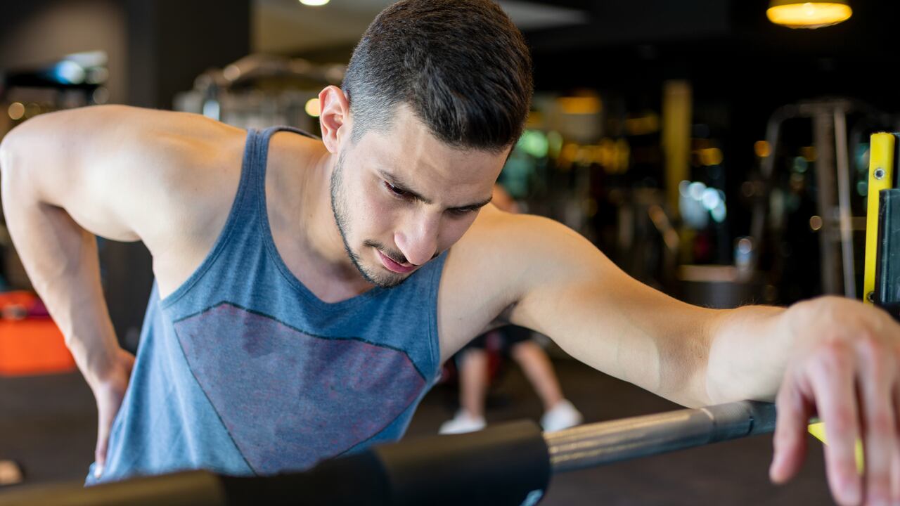 Hombre en el gimnasio con dolor lumbar.