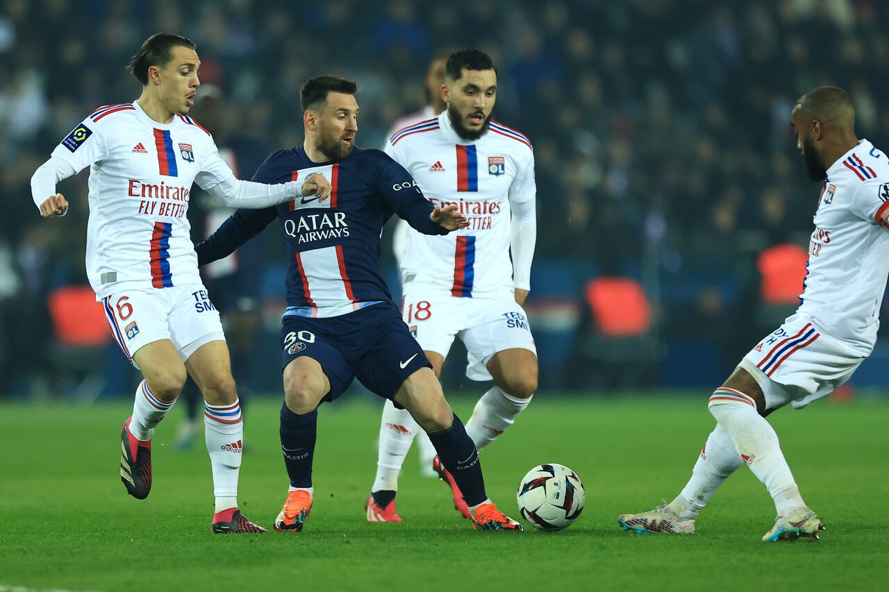 Lyon's Maxence Caqueret, left, Alexandre Lacazette, right, and Rayan Cherki, second from right, challenge for the ball with PSG's Lionel Messi during the French League One soccer match between Paris Saint-Germain and Lyon at the Parc des Princes stadium in Paris, Sunday, April 2, 2023. (AP Photo/Aurelien Morissard)