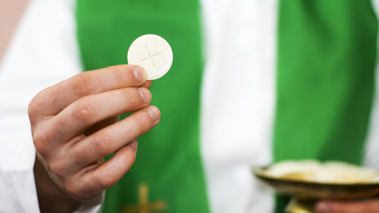 Sacerdote de la comunión en la mano