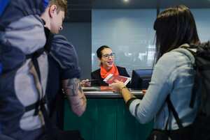 Young backpackers checking-in at airport line counter