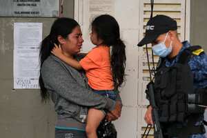 Una mujer y un niño esperan fuera de una cárcel para obtener el estatus de recluso después de un incendio mortal en la prisión de Tuluá, Colombia, el martes 28 de junio de 2022. Las autoridades dicen que al menos 49 personas murieron después de que estalló el incendio durante lo que parecía ser un intento disturbios la madrugada del martes. (Foto AP/Juan José Horta)