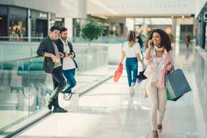 Young woman talking on phone in the shopping mall