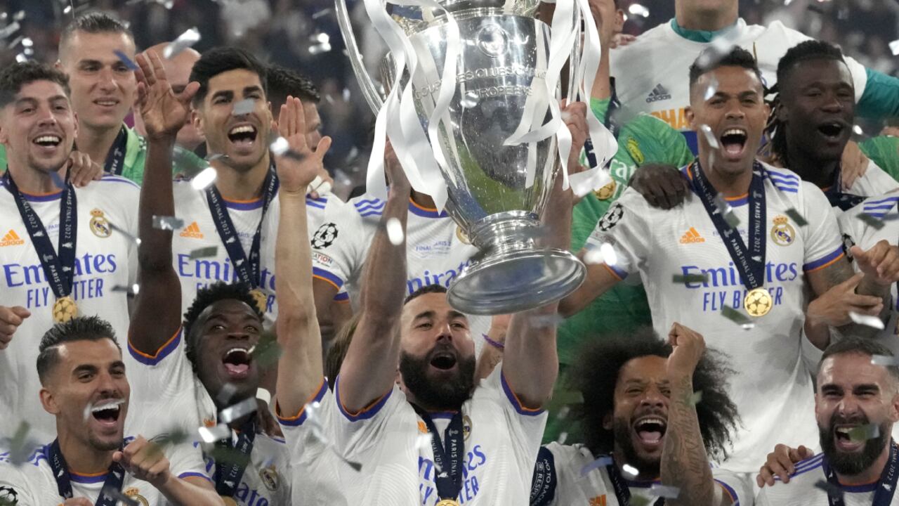 Real Madrid's Karim Benzema lifts the trophy as players celebrate winning the Champions League final soccer match between Liverpool and Real Madrid at the Stade de France in Saint Denis near Paris, Saturday, May 28, 2022. (AP/Frank Augstein)