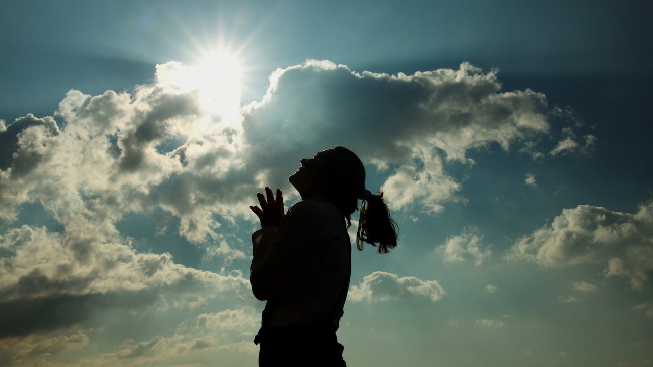 Mujer lanza una plegaria al cielo.
