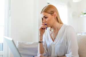 Anxious depressed woman sitting with laptop, looking nervous worried, scared of deadline stressful job.