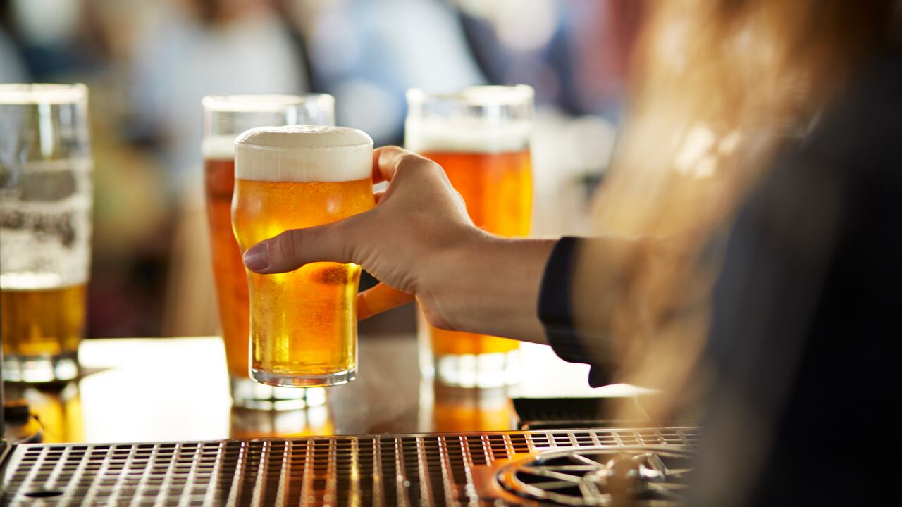 Close-up of bartender serving beers at bar