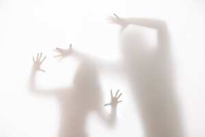 Conceptual image of a young woman deputing horror, pain and suffering from abuse by a Man.