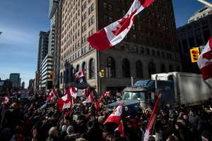 Camioneros y manifestantes se reúnen durante una protesta contra las restricciones por el COVID-19 en Toronto. Foto AP/Chris Young/The Canadian Press