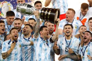 El argentino Lionel Messi sostiene el trofeo mientras celebra con sus compañeros de equipo después de vencer 1-0 a Brasil en la final de la Copa América en el estadio Maracaná de Río de Janeiro, Brasil, el sábado 10 de julio de 2021 (AP Photo / Andre Penner).