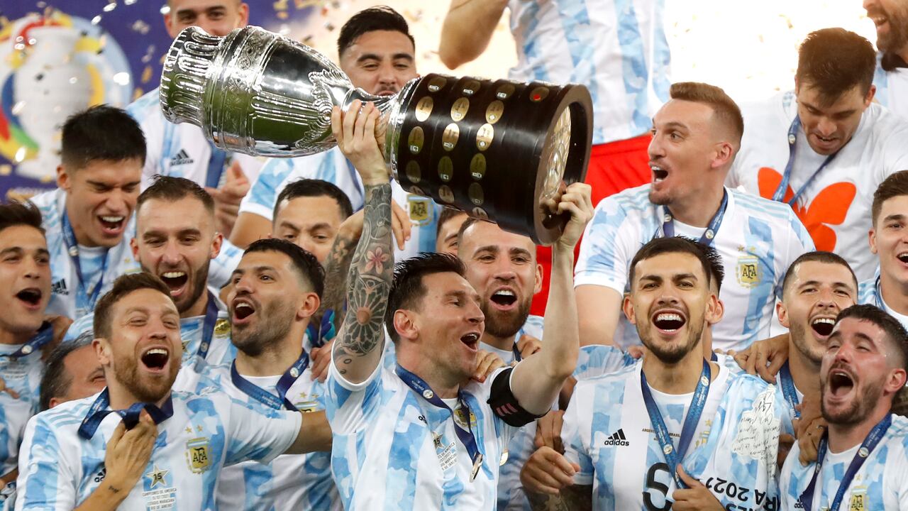 El argentino Lionel Messi sostiene el trofeo mientras celebra con sus compañeros de equipo después de vencer 1-0 a Brasil en la final de la Copa América en el estadio Maracaná de Río de Janeiro, Brasil, el sábado 10 de julio de 2021 (AP Photo / Andre Penner).