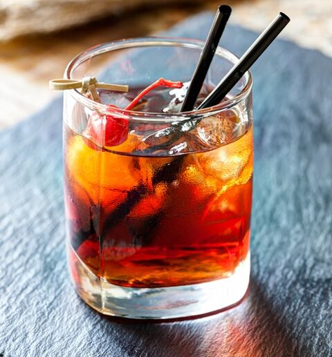 Glass of beautiful alcoholic cocktails with ice and cherry