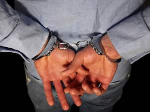 Handcuffs on arrested businessman hand, businessman loss freedom