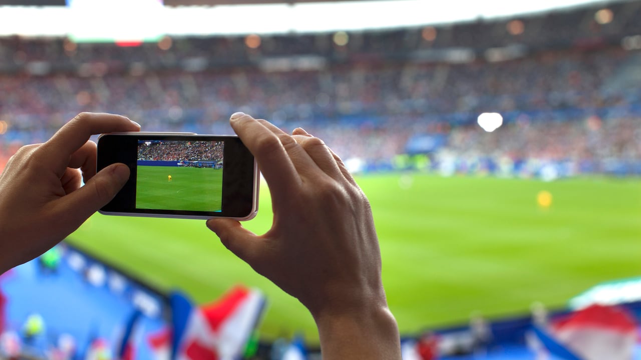 Persona graba con su celular en un estadio