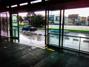 Speeding cars over a wet street from a bus station in a rainy day