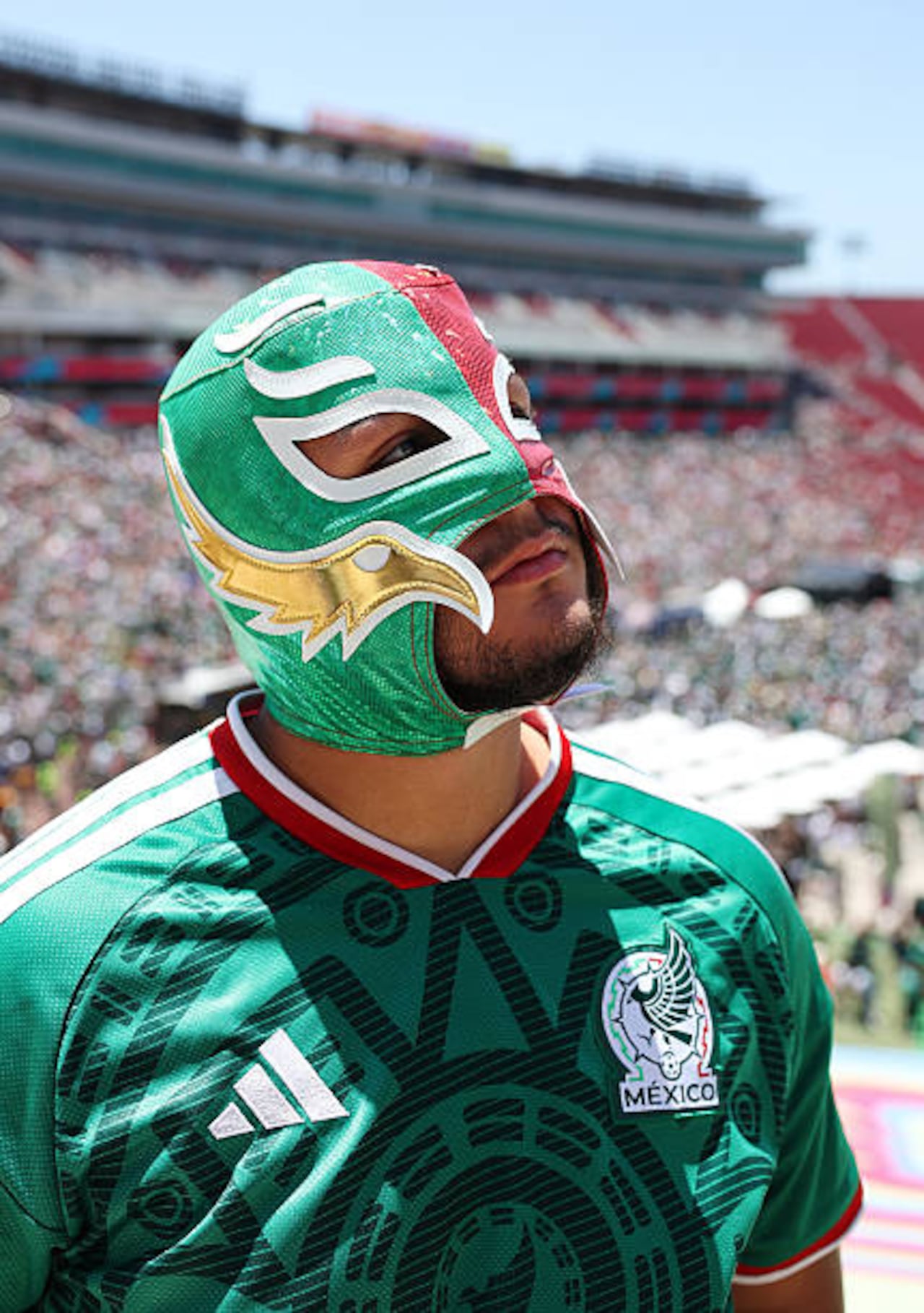 A fan of Mexico poses for a photo wearing a luchador mask at the LA Memorial Coliseum Fan Zone