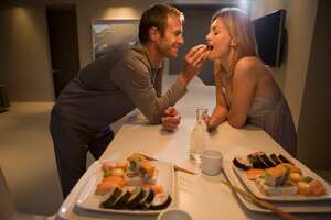 Pareja come bocados de comida de manera sensual.