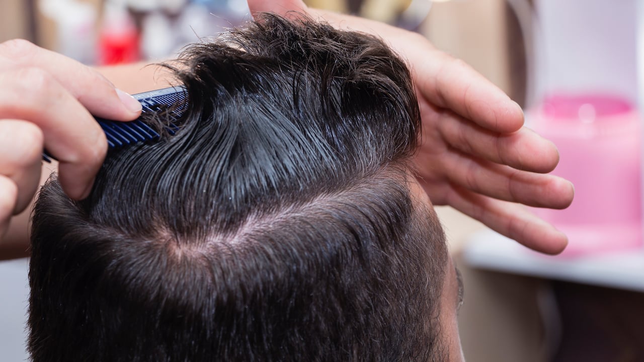 Peinado y cuidado del cabello para hombres con la ayuda de una máquina de tijeras y corte de cabello en la peluquería.