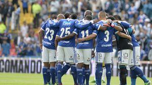 Jugadores de Millonarios hacen una piña en el centro del campo.